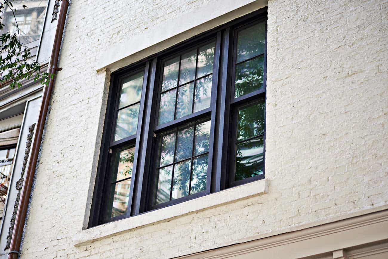 A window with a black frame on a white building.