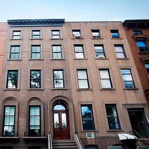 A row of brown brick buildings on a street in Brooklyn.