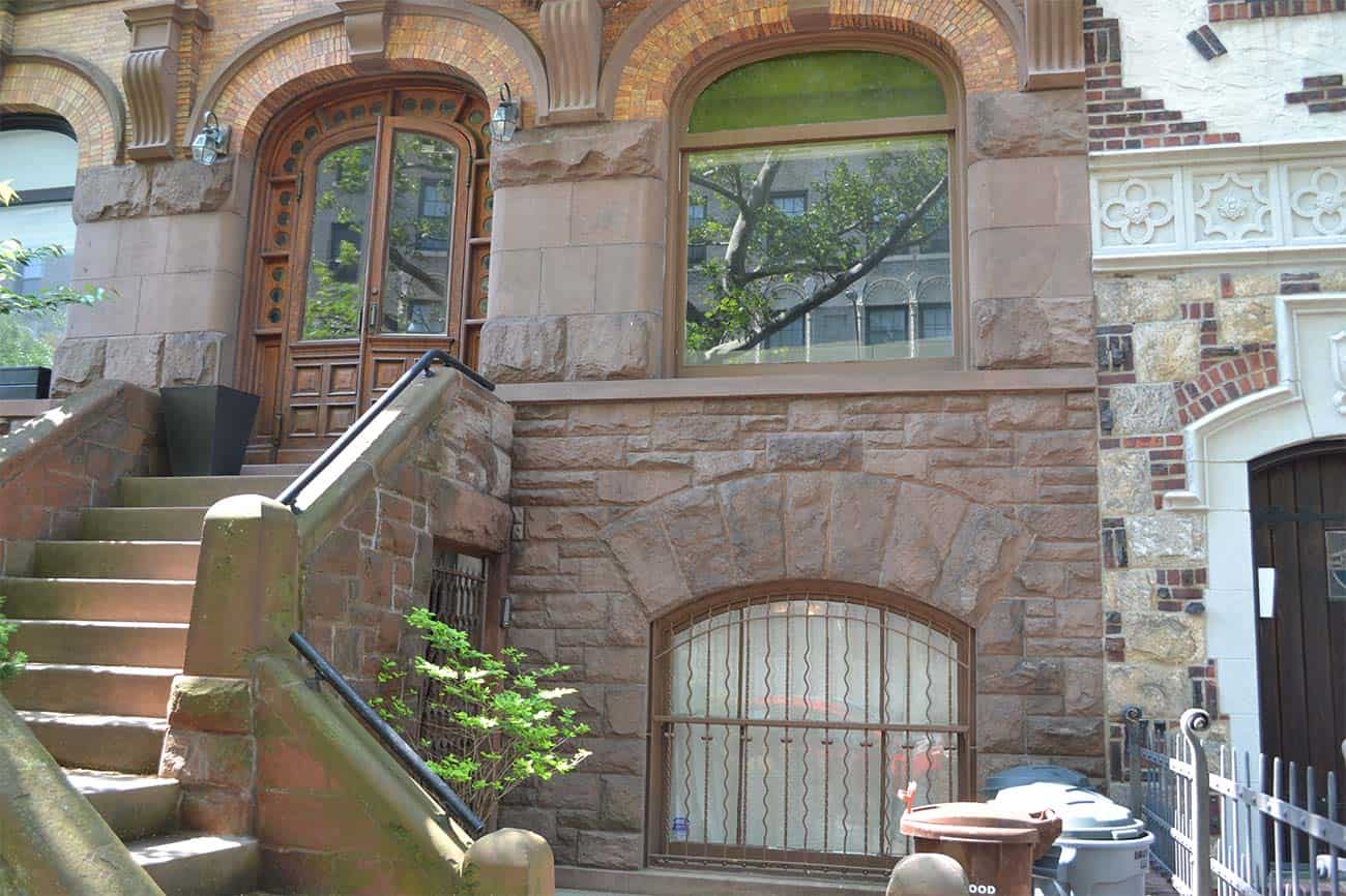 Stairs leading up to a Brooklyn brownstone building with arched windows made from ancient high-tech since 3500 BCE.