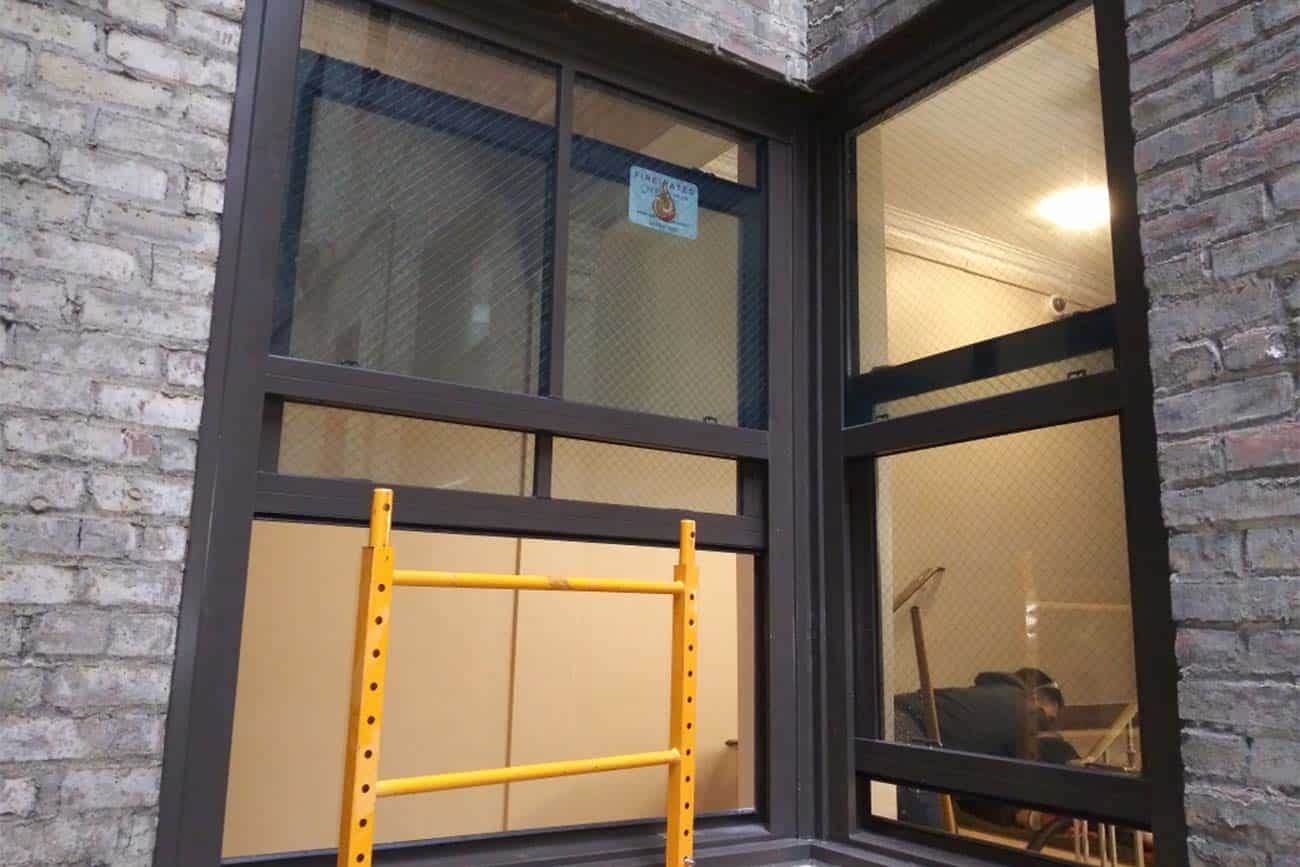 A window with a yellow fall safety guard.