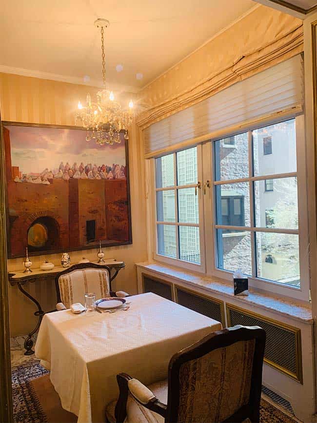 A dining room with a painting on the wall.