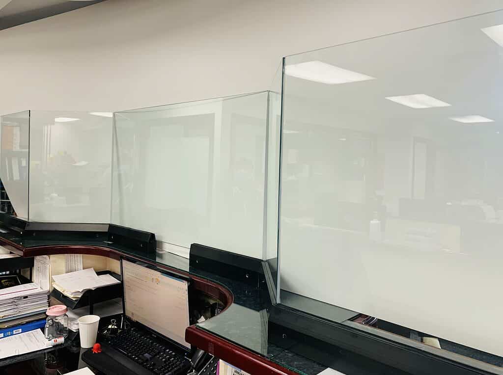 Protective glass barrier on service desk.