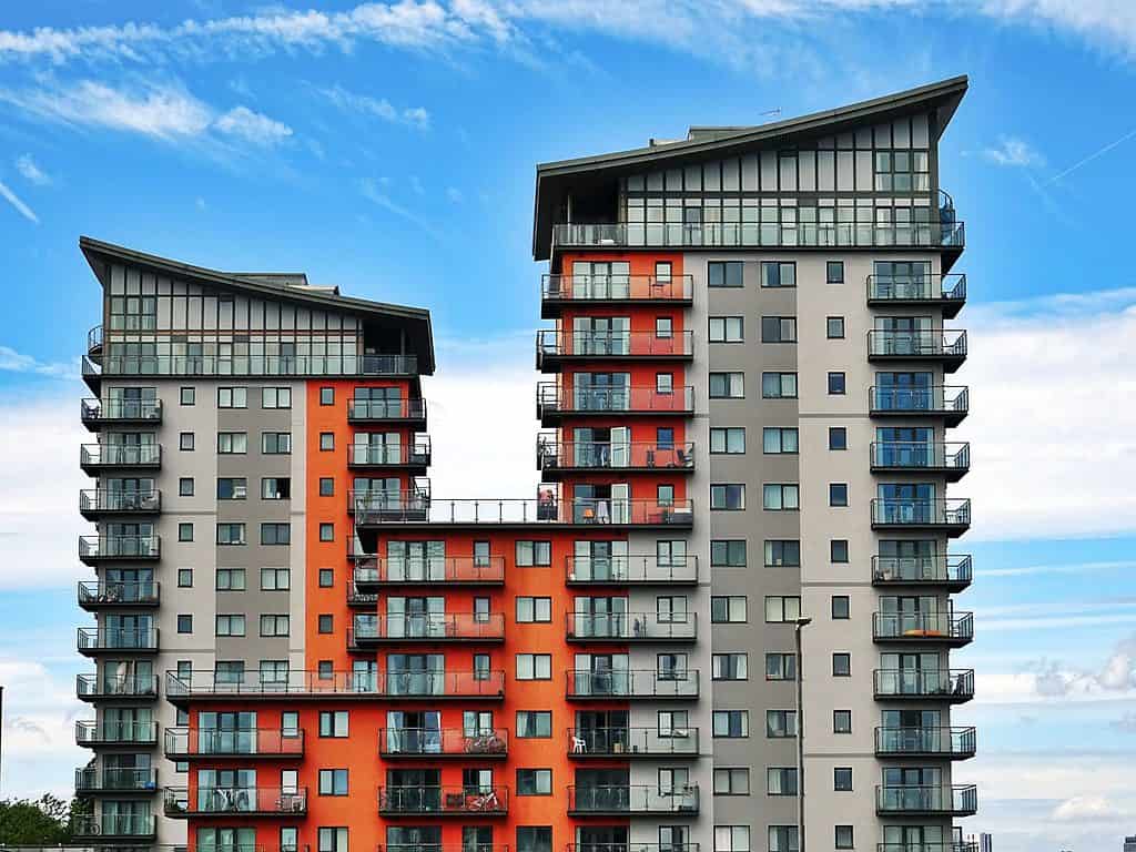 Tall, modern apartment complex against blue skyline.
