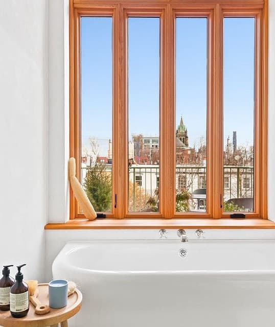 This is an image of custom wood windows installed in a bathroom in a condominium in Brooklyn, New York City.