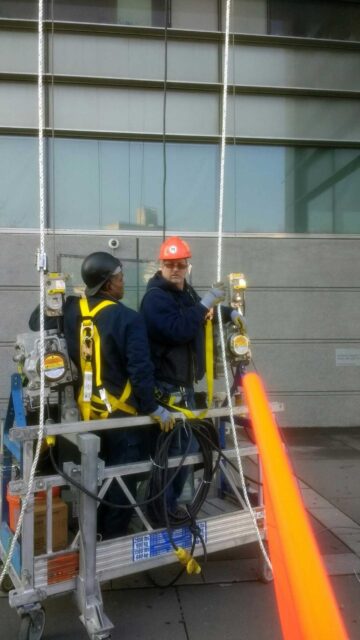 WindowFix employees on a lift replacing glass at the New York City Hall of Justice.