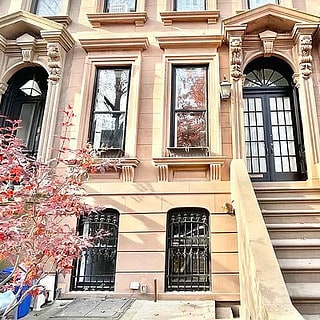 This is an absolutely lovely light-colored historic brownstone building in Brooklyn, New York City.