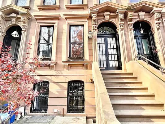 This is an absolutely lovely light-colored historic brownstone building in Brooklyn, New York City.