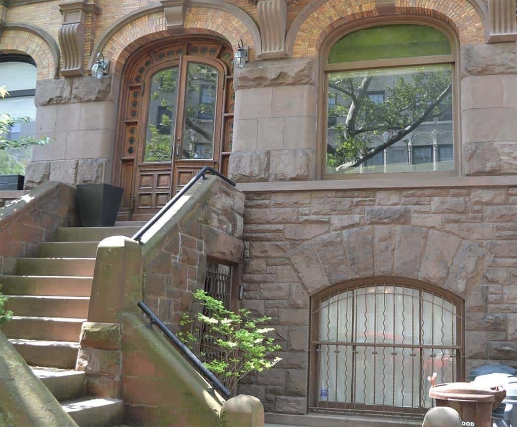 Stairs leading up to a Brooklyn New York City brownstone with arched windows, which are made from ancient high-tech knowledge since 3500 BCE.
