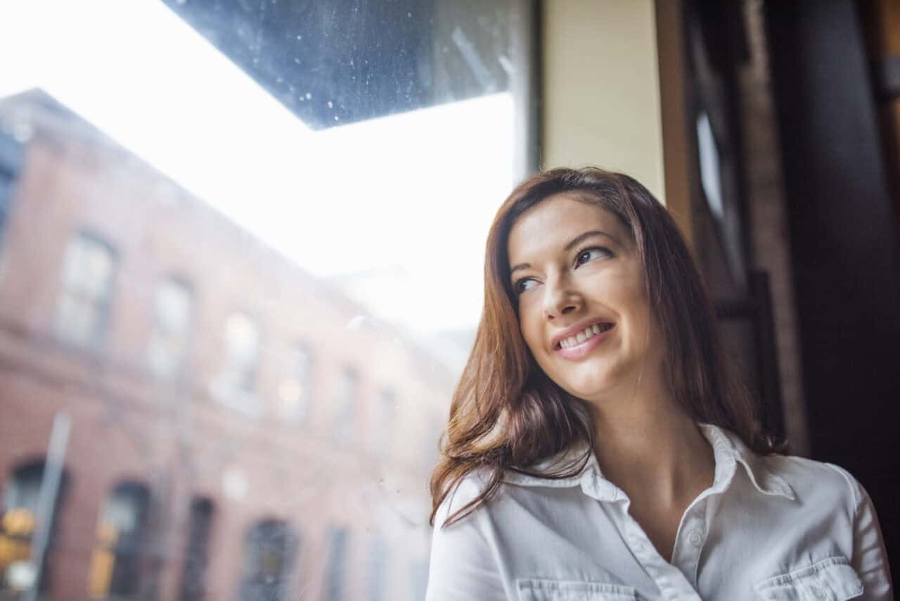 a woman looking out a window screen